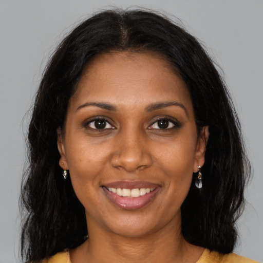 Joyful black young-adult female with long  brown hair and brown eyes