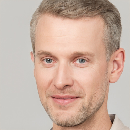 Joyful white adult male with short  brown hair and grey eyes