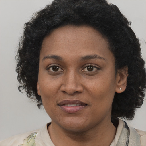 Joyful black young-adult female with short  black hair and brown eyes