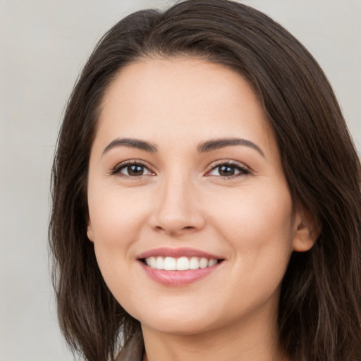 Joyful white young-adult female with long  brown hair and brown eyes