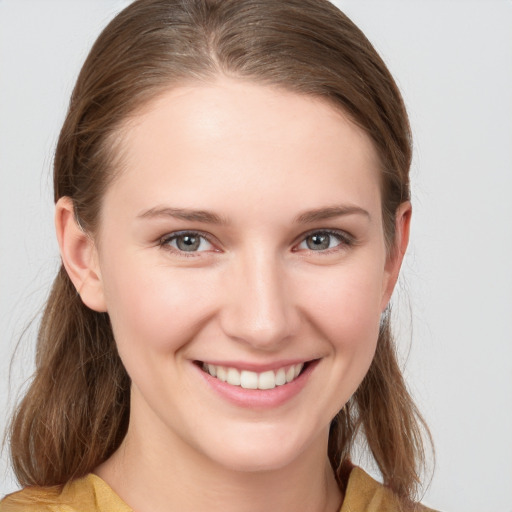 Joyful white young-adult female with medium  brown hair and grey eyes