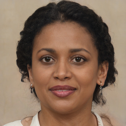 Joyful black young-adult female with medium  brown hair and brown eyes