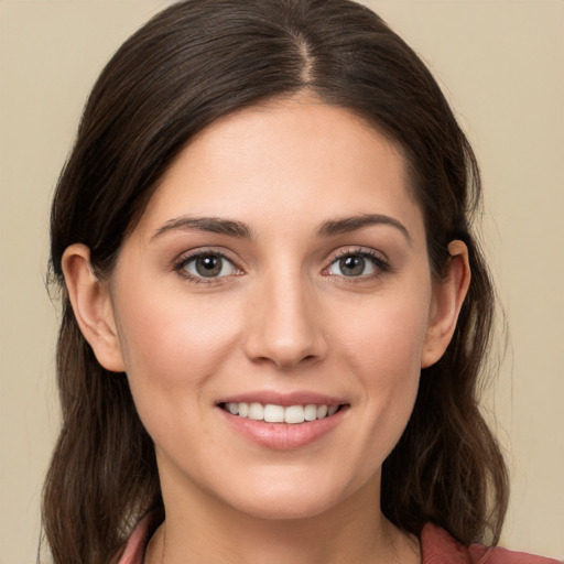 Joyful white young-adult female with long  brown hair and brown eyes