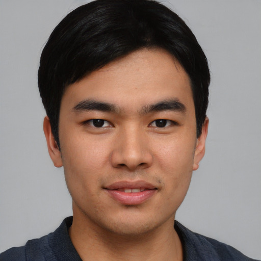 Joyful asian young-adult male with short  black hair and brown eyes