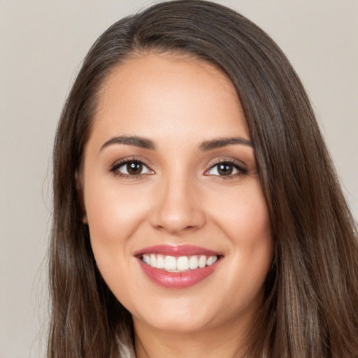 Joyful white young-adult female with long  brown hair and brown eyes