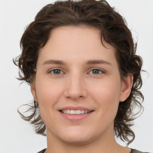 Joyful white young-adult female with medium  brown hair and green eyes