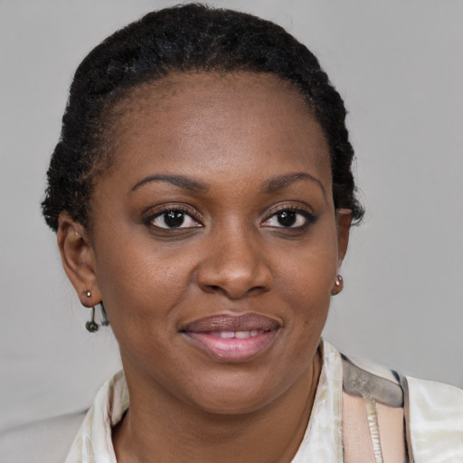 Joyful black young-adult female with short  brown hair and brown eyes