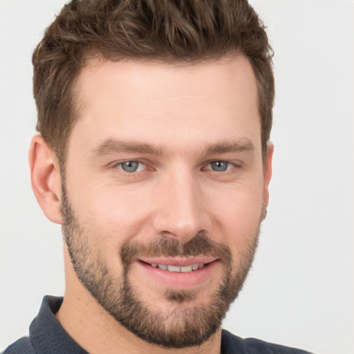 Joyful white young-adult male with short  brown hair and grey eyes