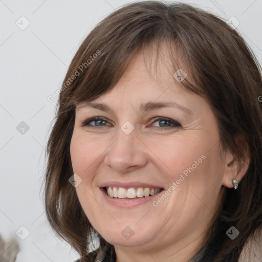 Joyful white adult female with long  brown hair and grey eyes