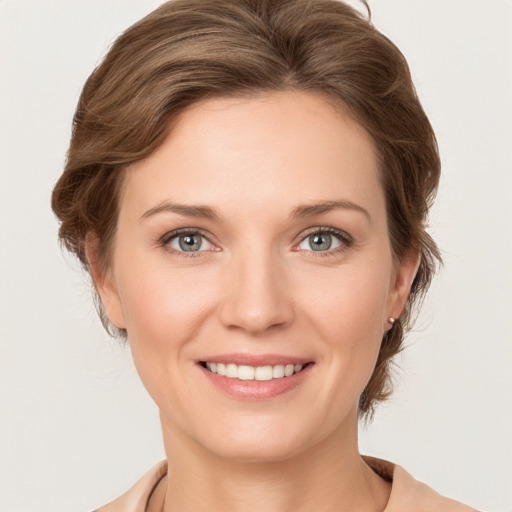 Joyful white young-adult female with medium  brown hair and grey eyes