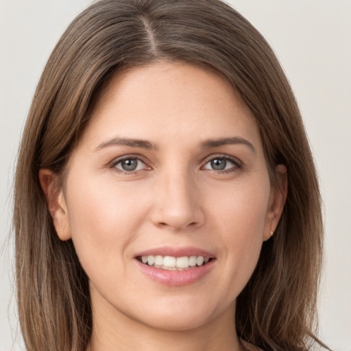 Joyful white young-adult female with long  brown hair and grey eyes