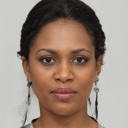 Joyful black young-adult female with long  brown hair and brown eyes