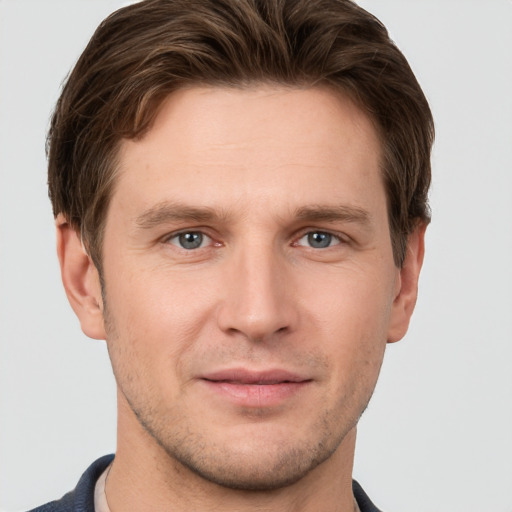 Joyful white young-adult male with short  brown hair and grey eyes