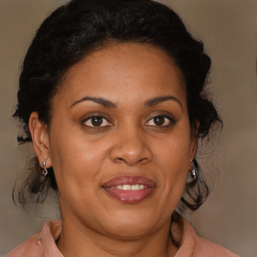 Joyful latino adult female with medium  brown hair and brown eyes