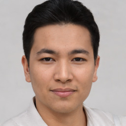 Joyful asian young-adult male with short  brown hair and brown eyes