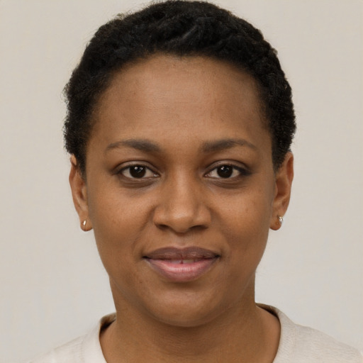 Joyful black young-adult female with short  black hair and brown eyes