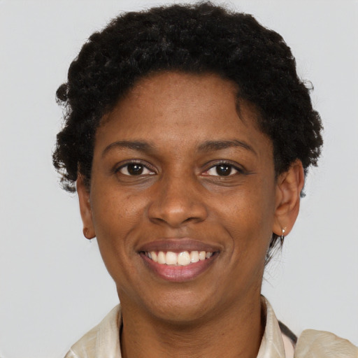 Joyful black young-adult female with short  brown hair and brown eyes