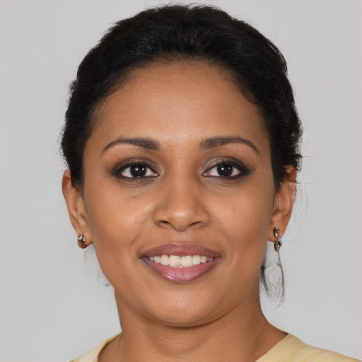 Joyful black young-adult female with medium  brown hair and brown eyes
