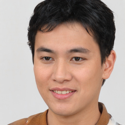 Joyful asian young-adult male with short  brown hair and brown eyes