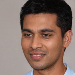 Joyful latino young-adult male with short  black hair and brown eyes