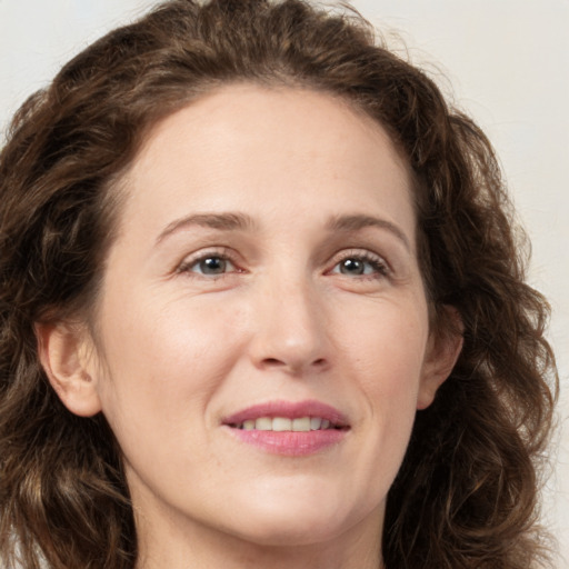 Joyful white young-adult female with long  brown hair and green eyes