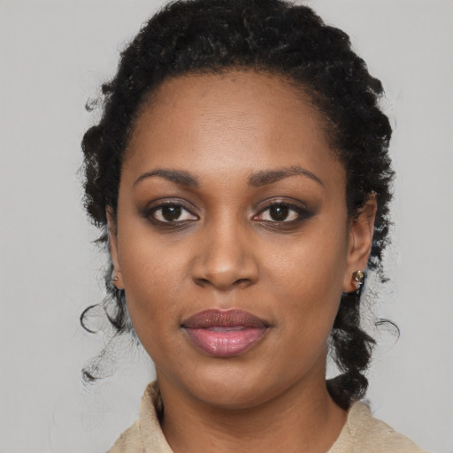 Joyful black young-adult female with long  black hair and brown eyes