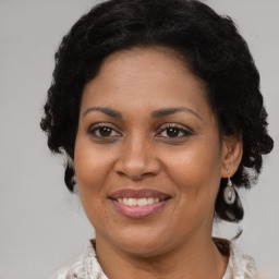 Joyful black adult female with medium  brown hair and brown eyes