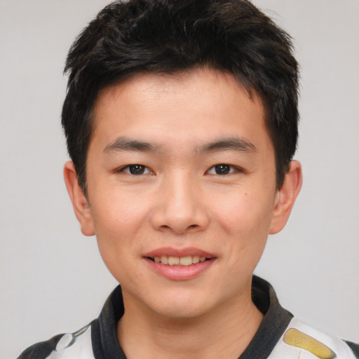 Joyful asian young-adult male with short  black hair and brown eyes