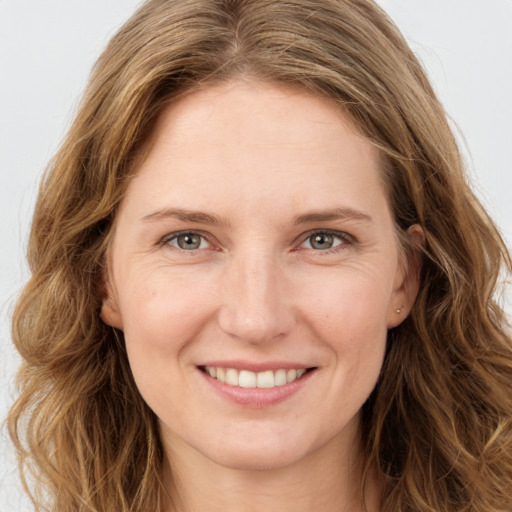 Joyful white young-adult female with long  brown hair and green eyes