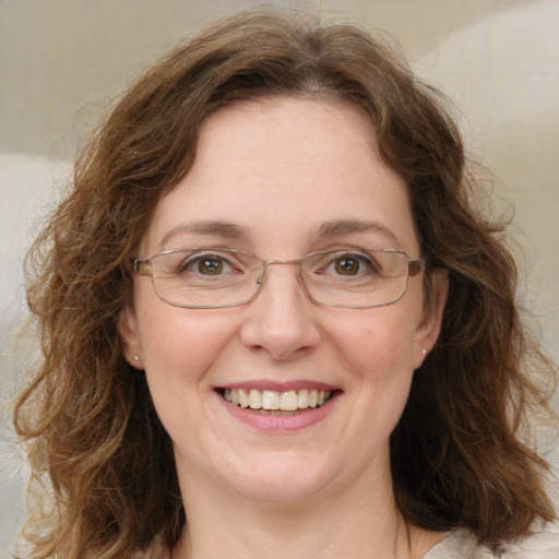 Joyful white adult female with medium  brown hair and green eyes