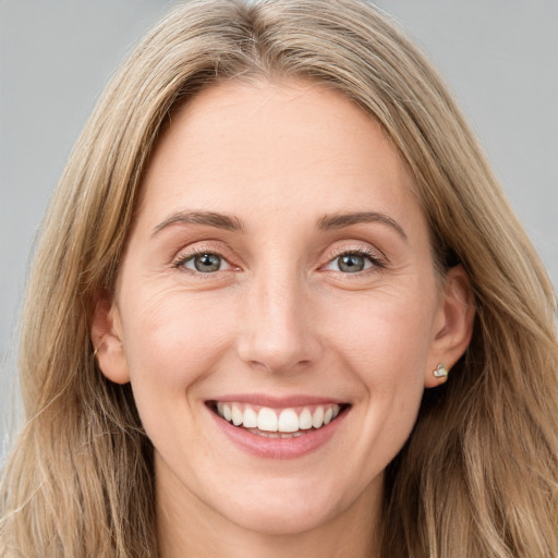 Joyful white young-adult female with long  brown hair and blue eyes