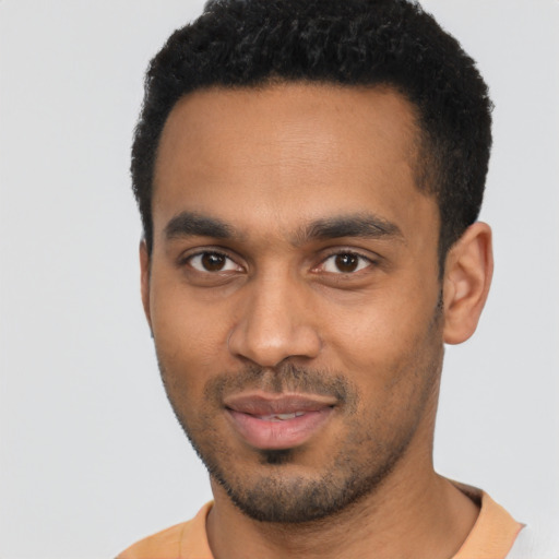 Joyful black young-adult male with short  black hair and brown eyes