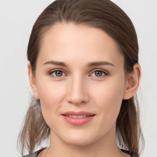 Joyful white young-adult female with medium  brown hair and grey eyes