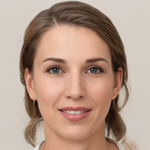 Joyful white young-adult female with medium  brown hair and grey eyes