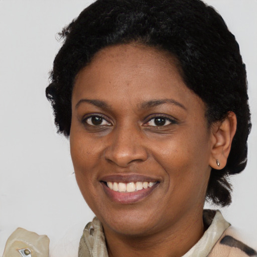 Joyful black adult female with short  black hair and brown eyes