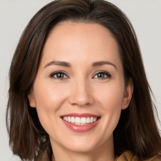 Joyful white young-adult female with long  brown hair and brown eyes