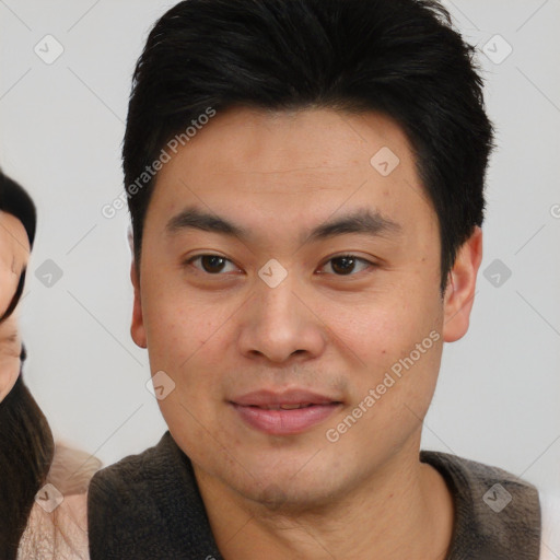 Joyful asian young-adult male with short  brown hair and brown eyes