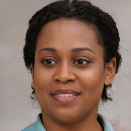 Joyful black young-adult female with long  brown hair and brown eyes