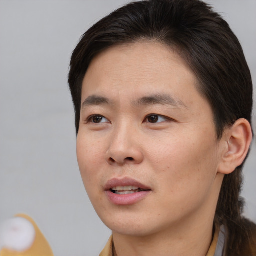 Joyful asian young-adult male with short  brown hair and brown eyes