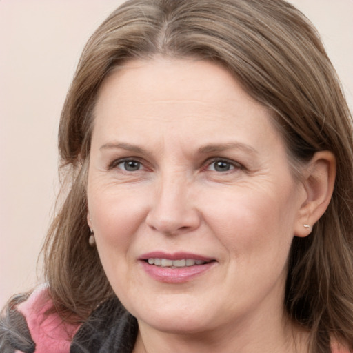 Joyful white adult female with medium  brown hair and grey eyes