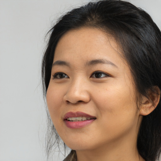 Joyful asian young-adult female with long  brown hair and brown eyes