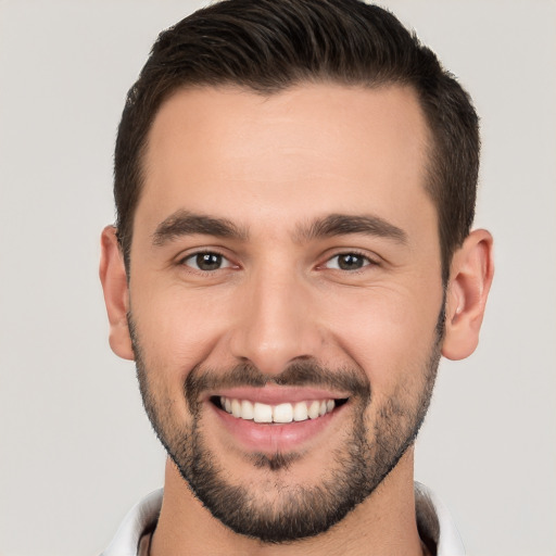 Joyful white young-adult male with short  black hair and brown eyes