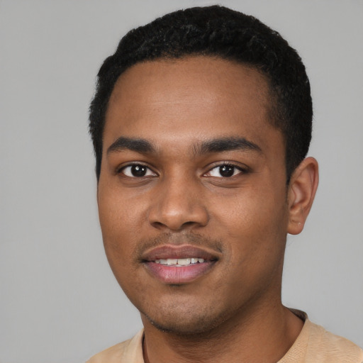 Joyful black young-adult male with short  black hair and brown eyes