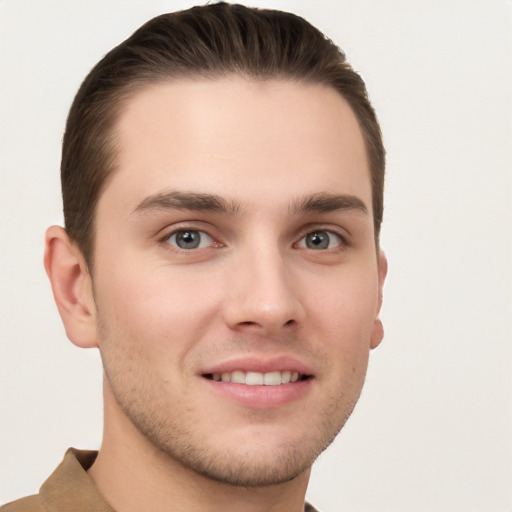 Joyful white young-adult male with short  brown hair and grey eyes