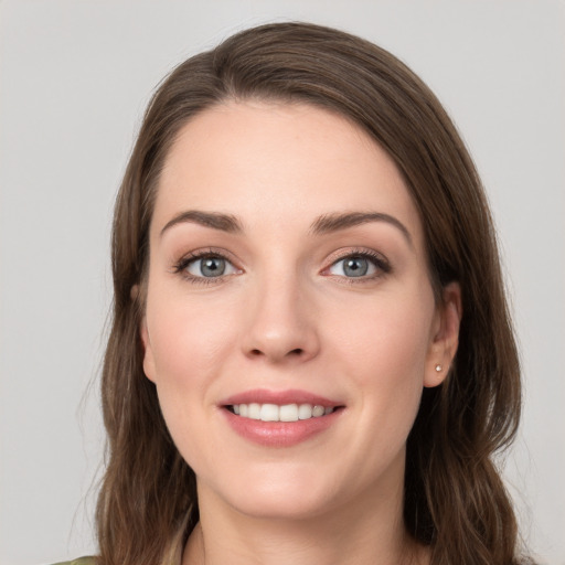 Joyful white young-adult female with long  brown hair and grey eyes