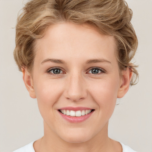 Joyful white young-adult female with short  brown hair and green eyes