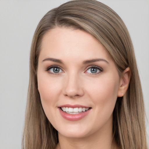 Joyful white young-adult female with long  brown hair and grey eyes