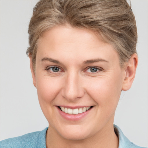 Joyful white young-adult female with short  brown hair and grey eyes