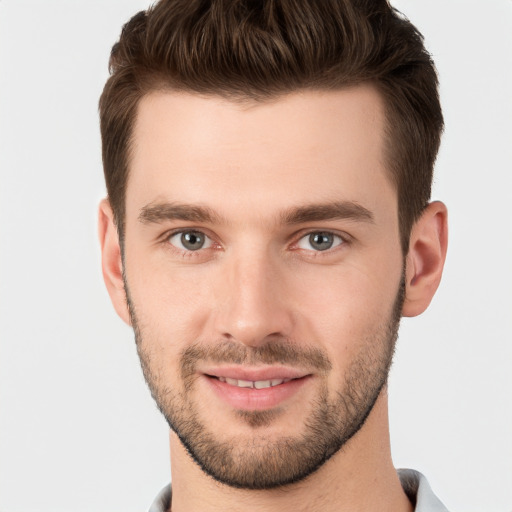 Joyful white young-adult male with short  brown hair and grey eyes