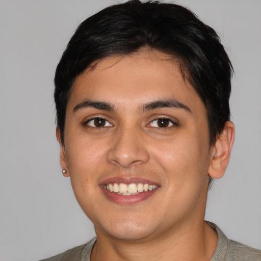 Joyful latino young-adult male with short  black hair and brown eyes